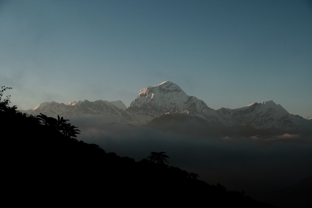 a view of a mountain range with clouds in the foreground