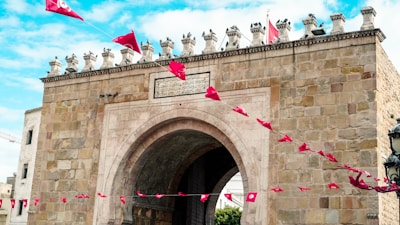 a stone gate with a red kite flying in the air