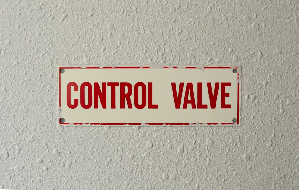 a red and white sign that reads control valve