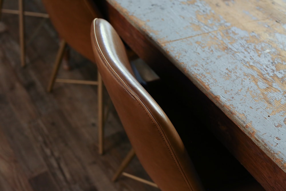a close up of a wooden table with chairs