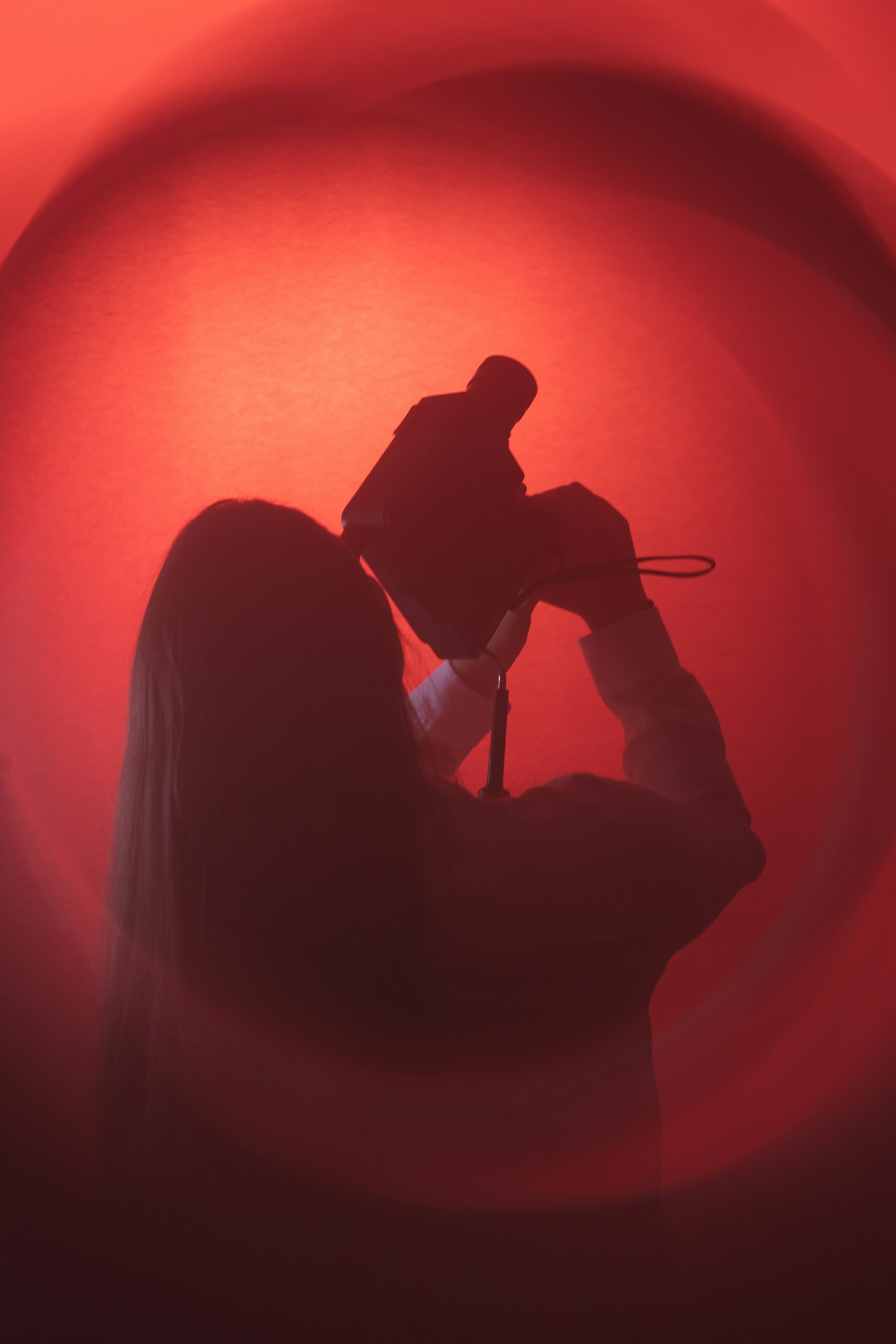 Eine Frau, die eine Kamera vor ihr Gesicht hält