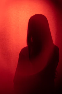 Artistic silhouette of Gwen against a deep red background, embodying sacred feminine energy