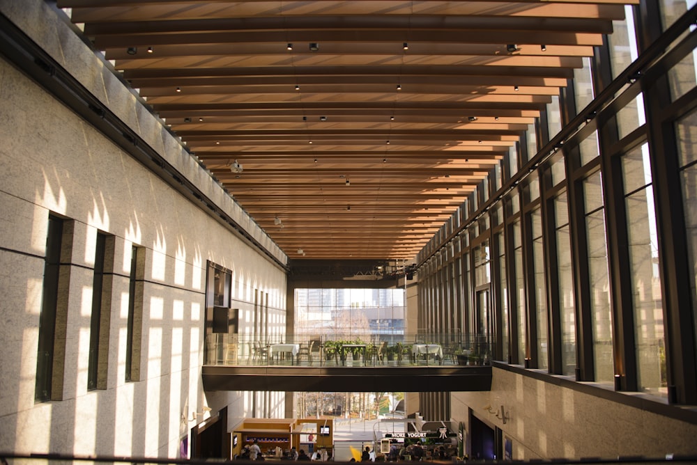 a long hallway with a wooden ceiling and windows