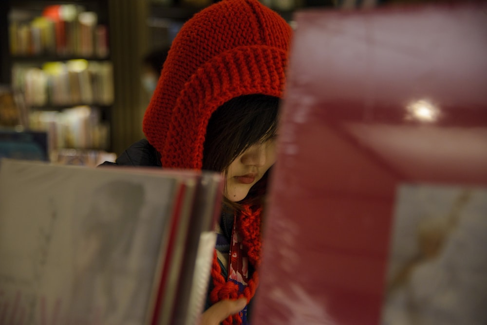 a little girl wearing a red hat and scarf