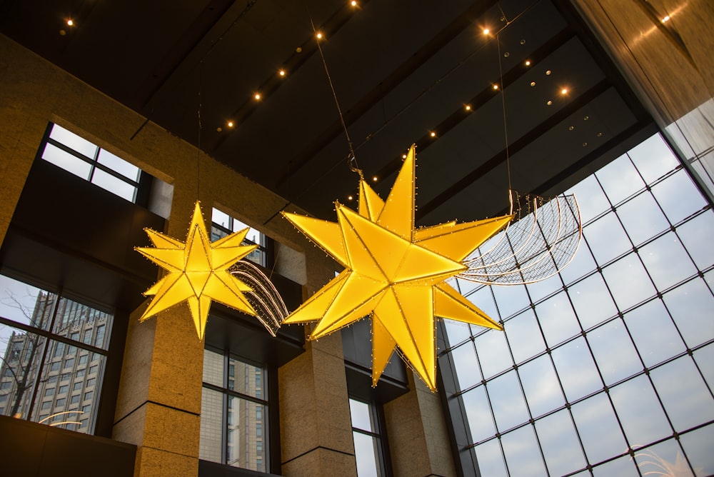 three yellow stars hanging from the ceiling of a building