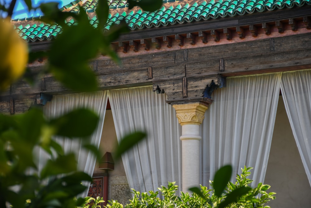 a building with a green roof and white curtains