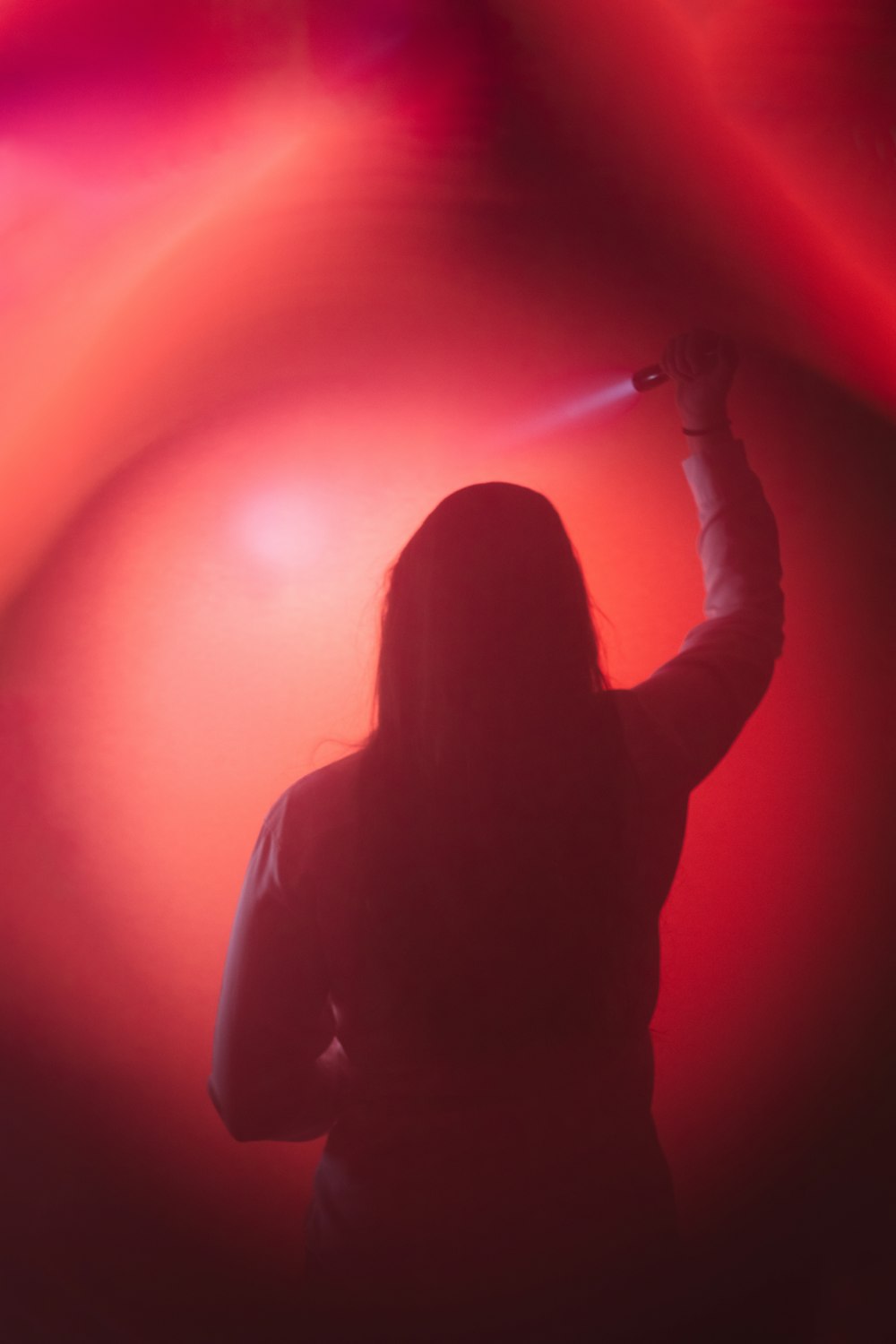 a woman standing in front of a red light
