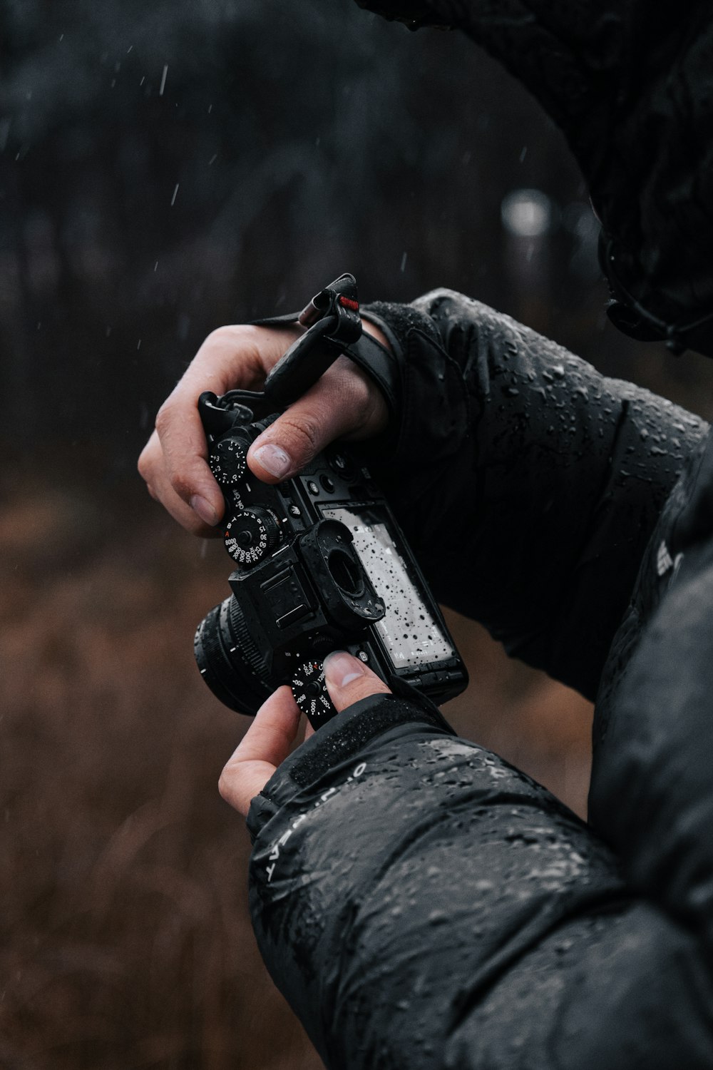 a person holding a camera in the rain