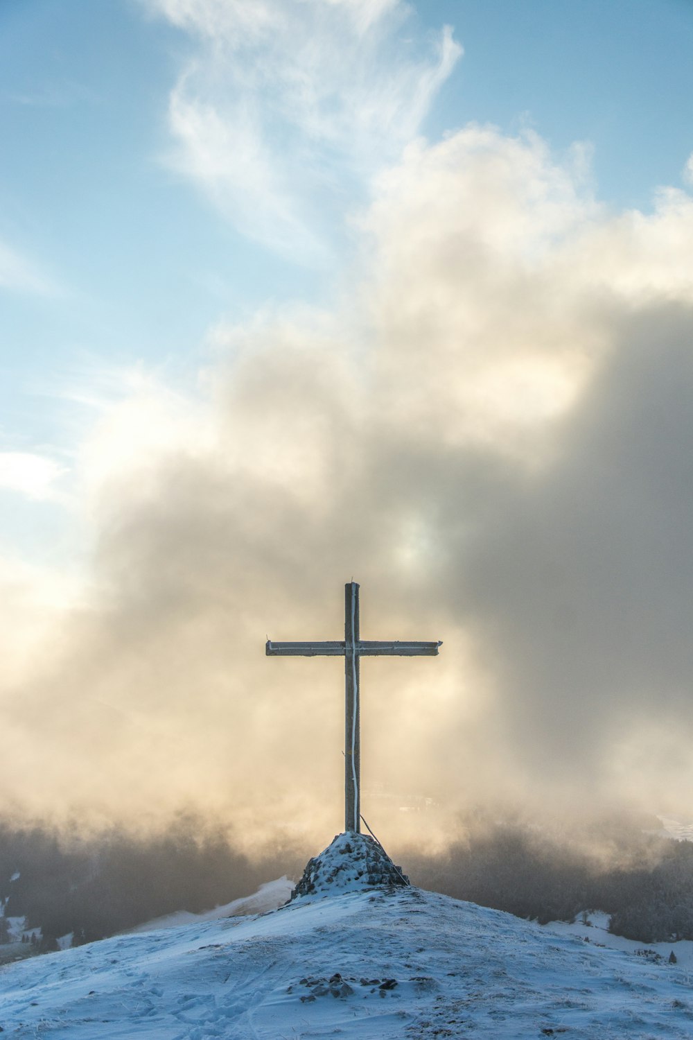 a cross on top of a snow covered hill