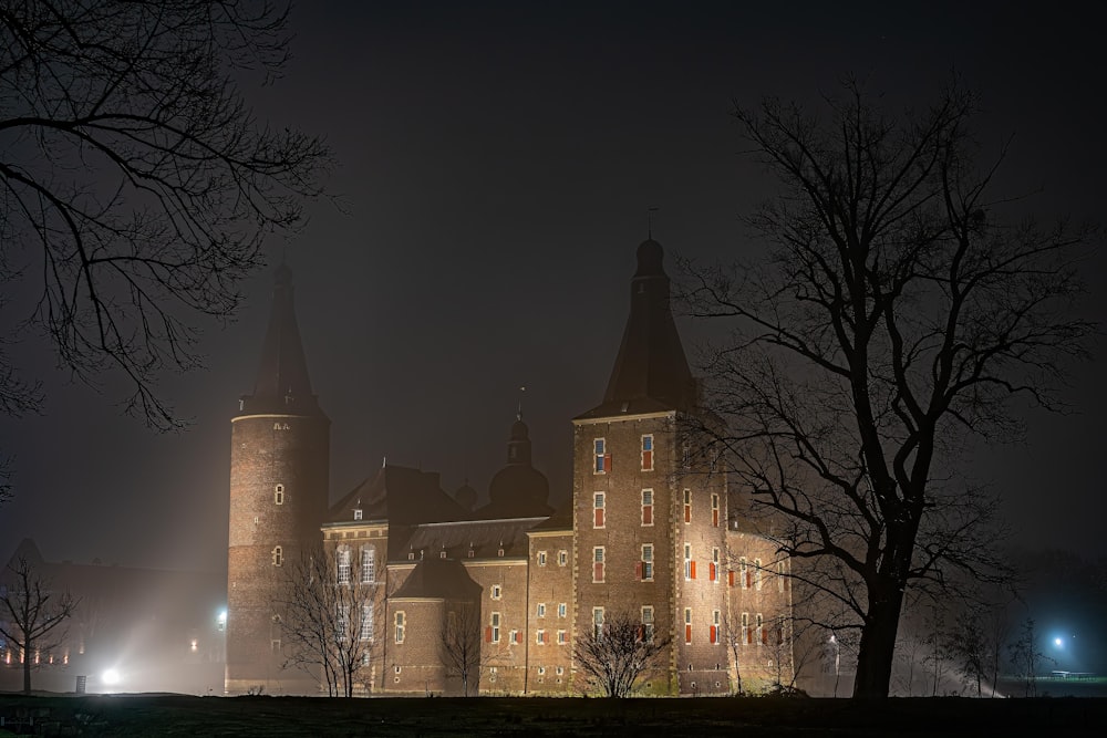 Un grand bâtiment avec une tour de l’horloge la nuit