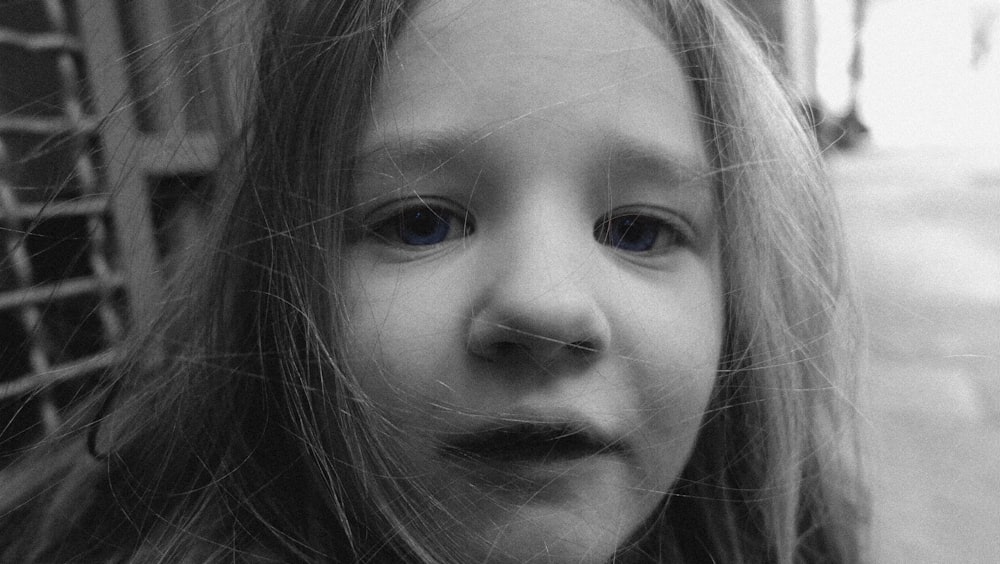 a close up of a child with long hair