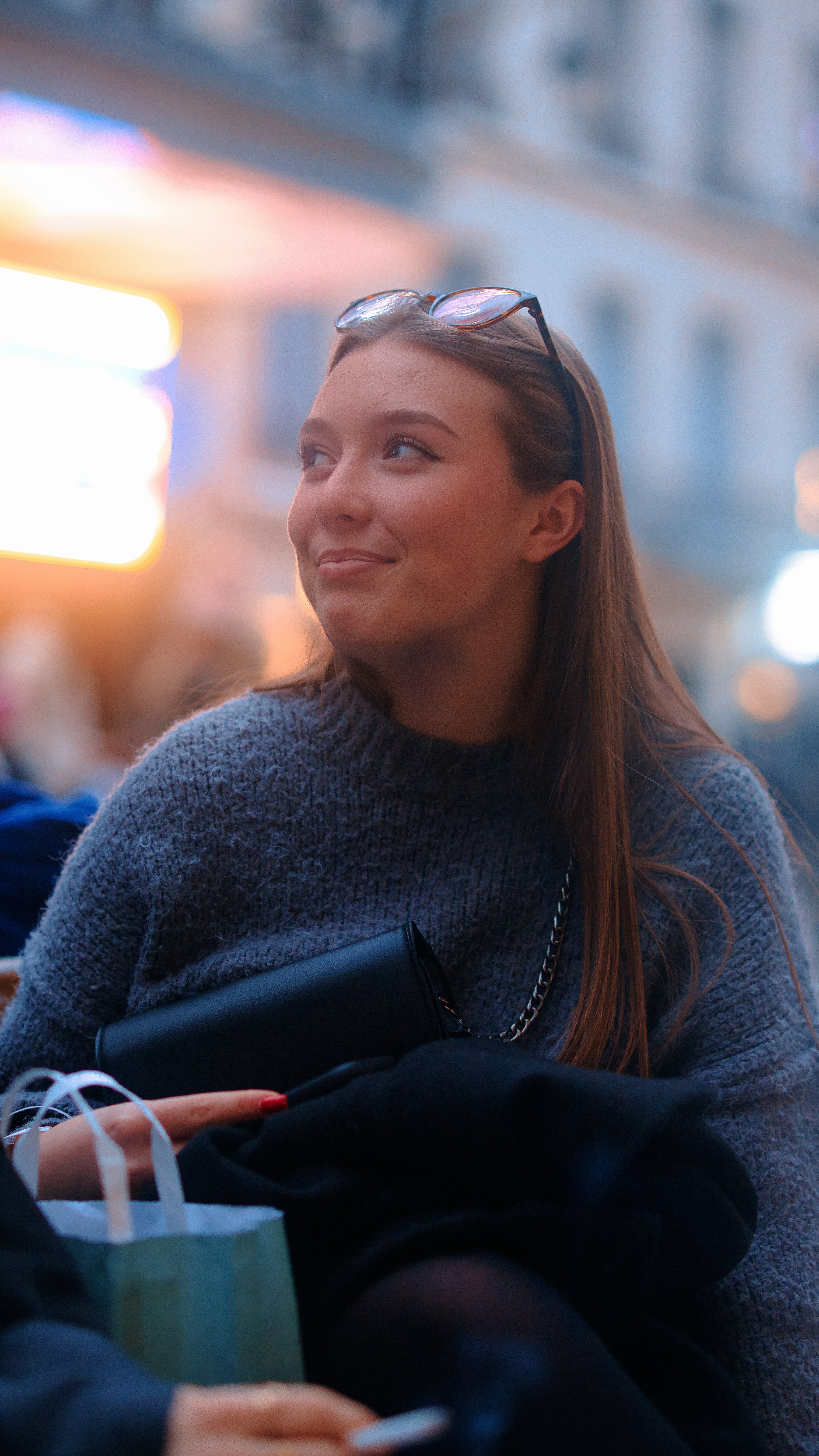 a woman sitting on a bench with a shopping bag