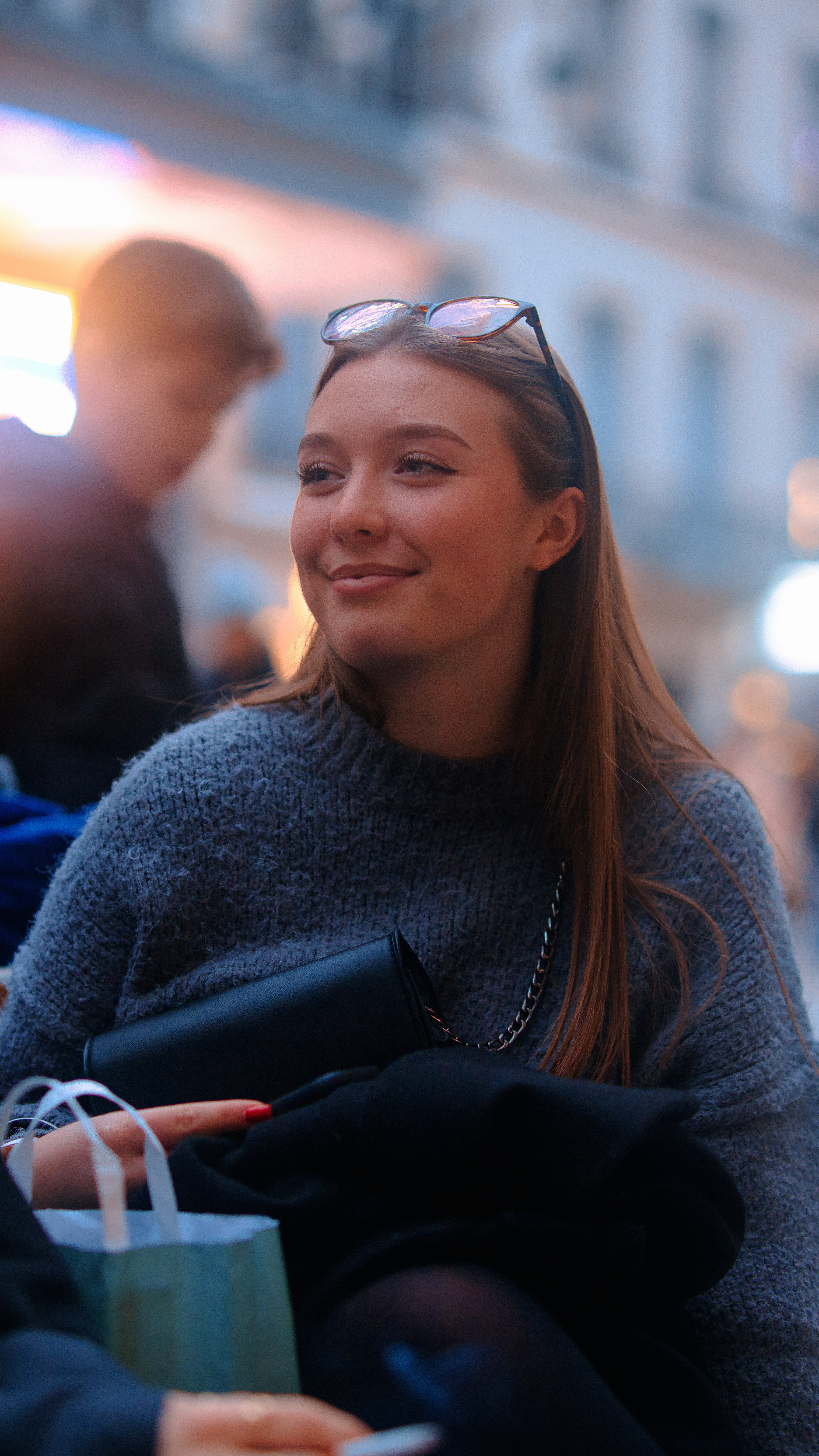 a woman sitting on a bench with a shopping bag
