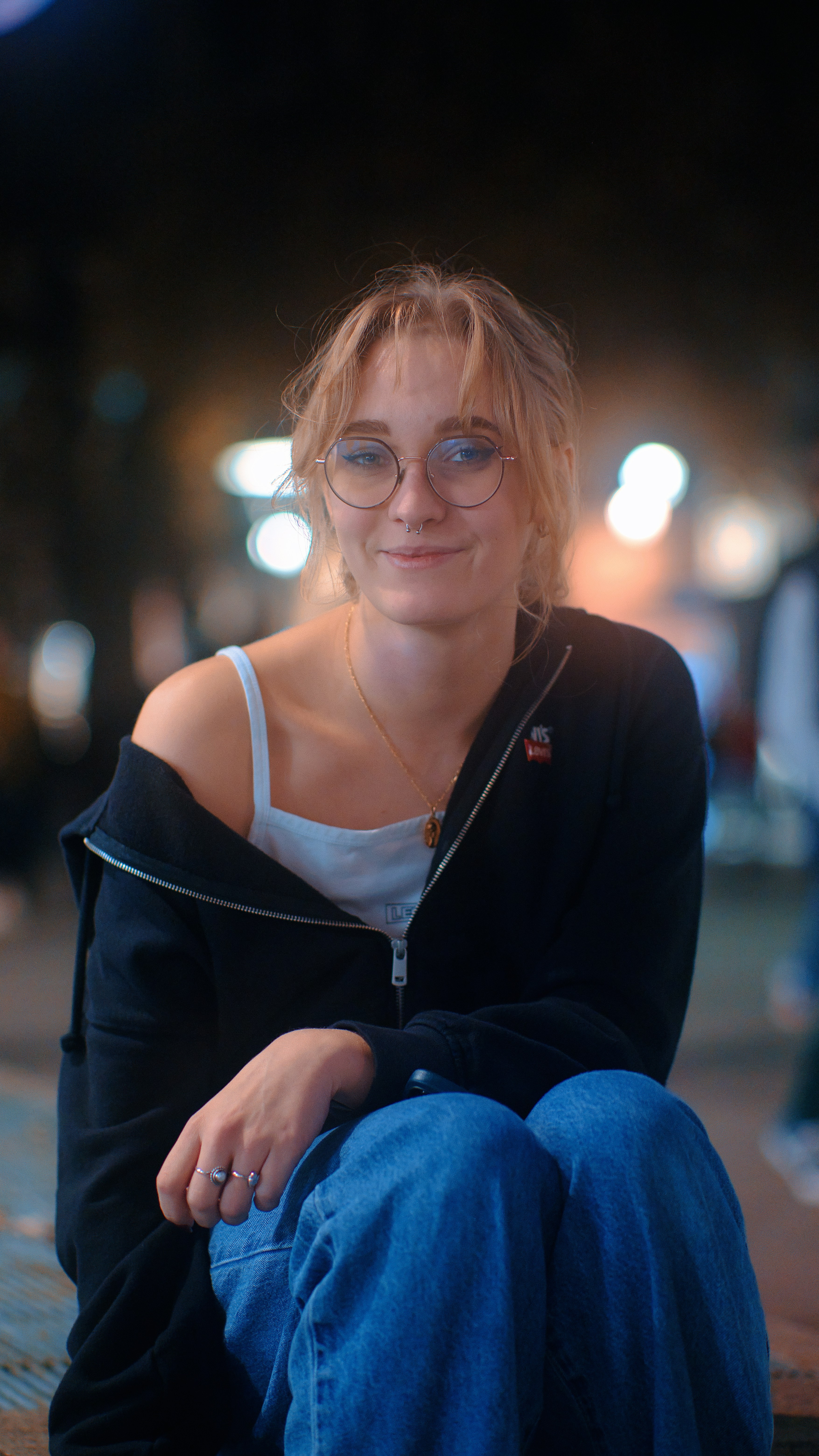 a woman wearing glasses sitting on a bench