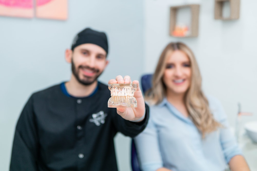 a man and a woman holding up a toothbrush