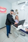 a man standing next to a woman on a laptop