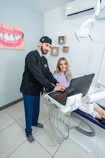 A smiling dental staff member assisting a patient at the reception.