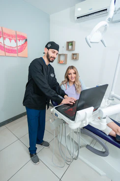 Smiling dentist gently examining a patient's teeth in a bright and welcoming clinic room.