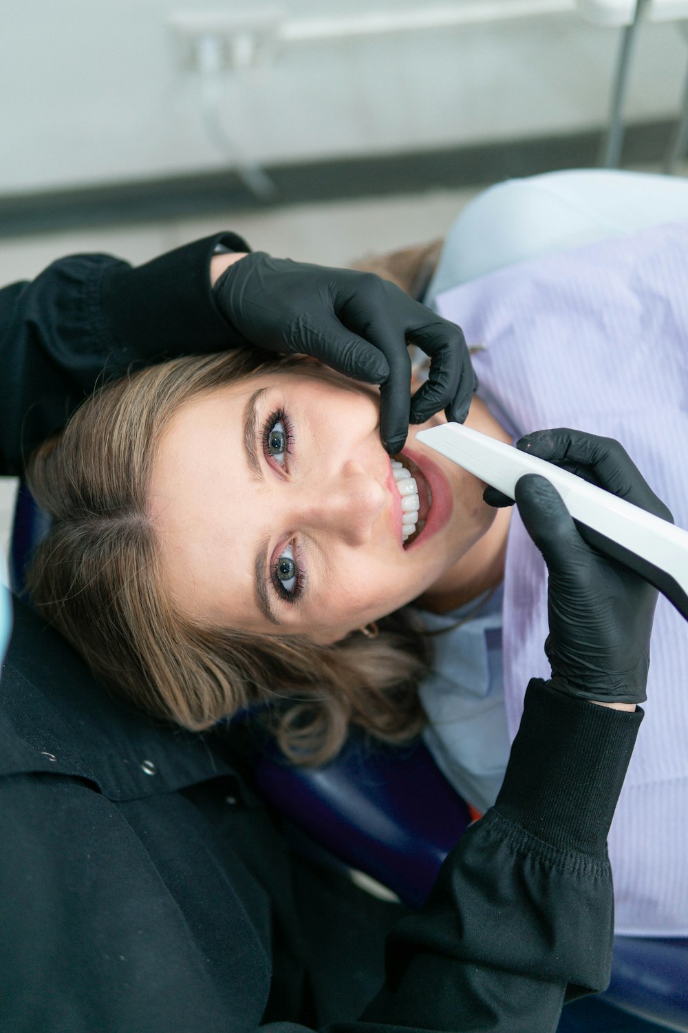 a woman is smiling while holding a toothbrush