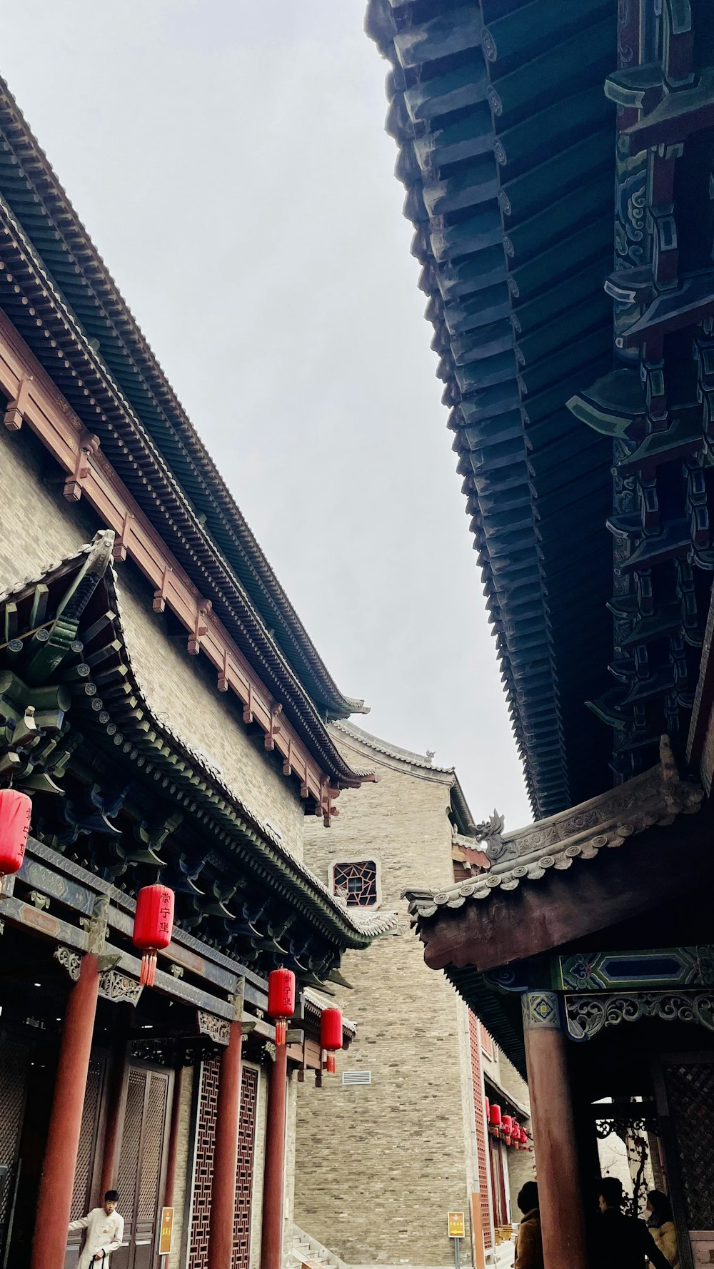 a couple of red lanterns hanging from the side of a building