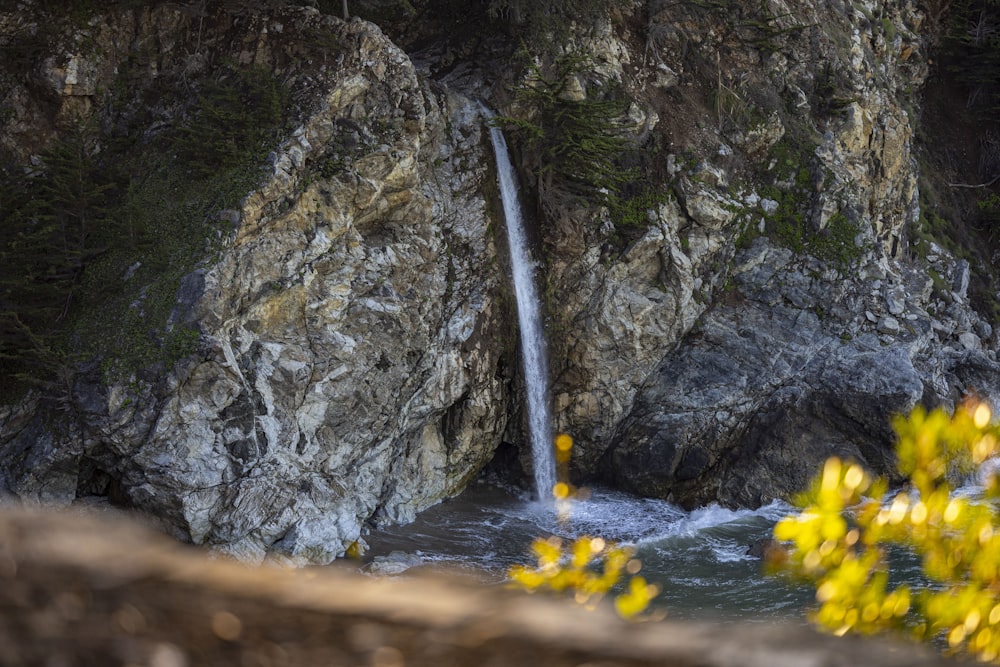 a small waterfall is coming out of the rocks