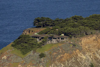 Modern sustainable coastal house with large glass facades blending into rugged Scottish terrain.
