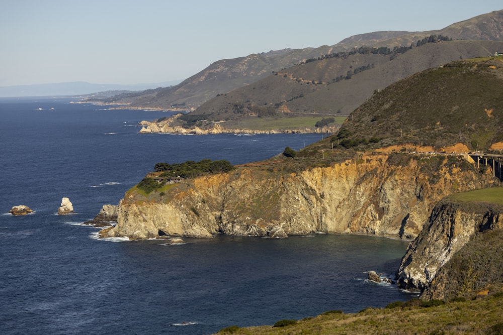 a scenic view of the ocean with a bridge in the distance