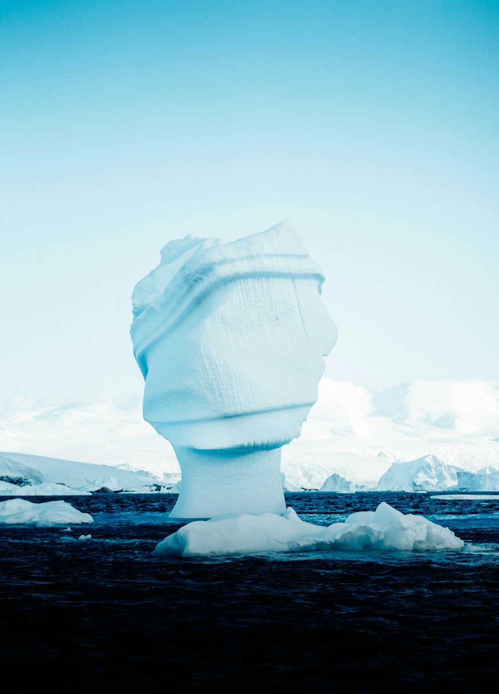 un grand iceberg flottant au-dessus d’un plan d’eau