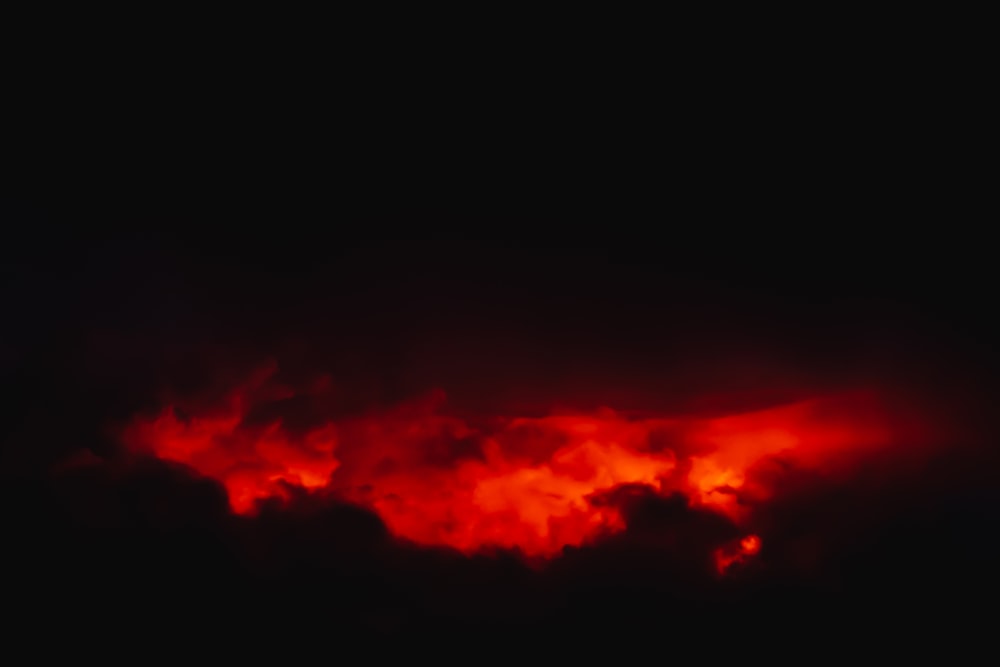 a dark sky with red clouds in it