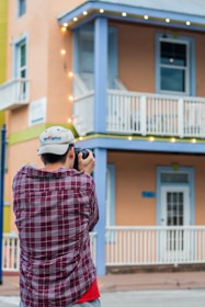 A professional photographer taking pictures of a stylish coastal rental home.
