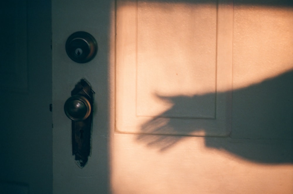 a shadow of a hand on a door handle