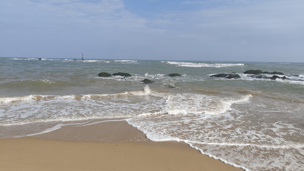 a sandy beach with waves coming in to shore