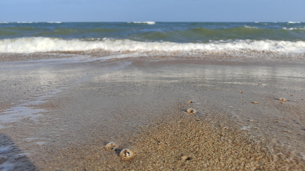 a sandy beach with waves coming in to shore