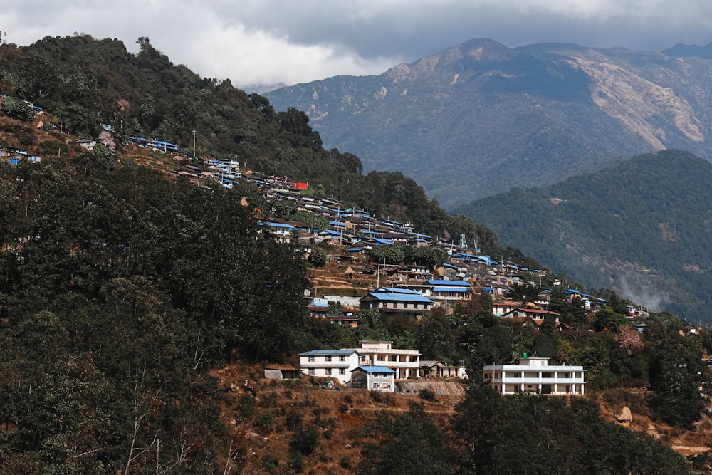 a hillside with houses on it and mountains in the background