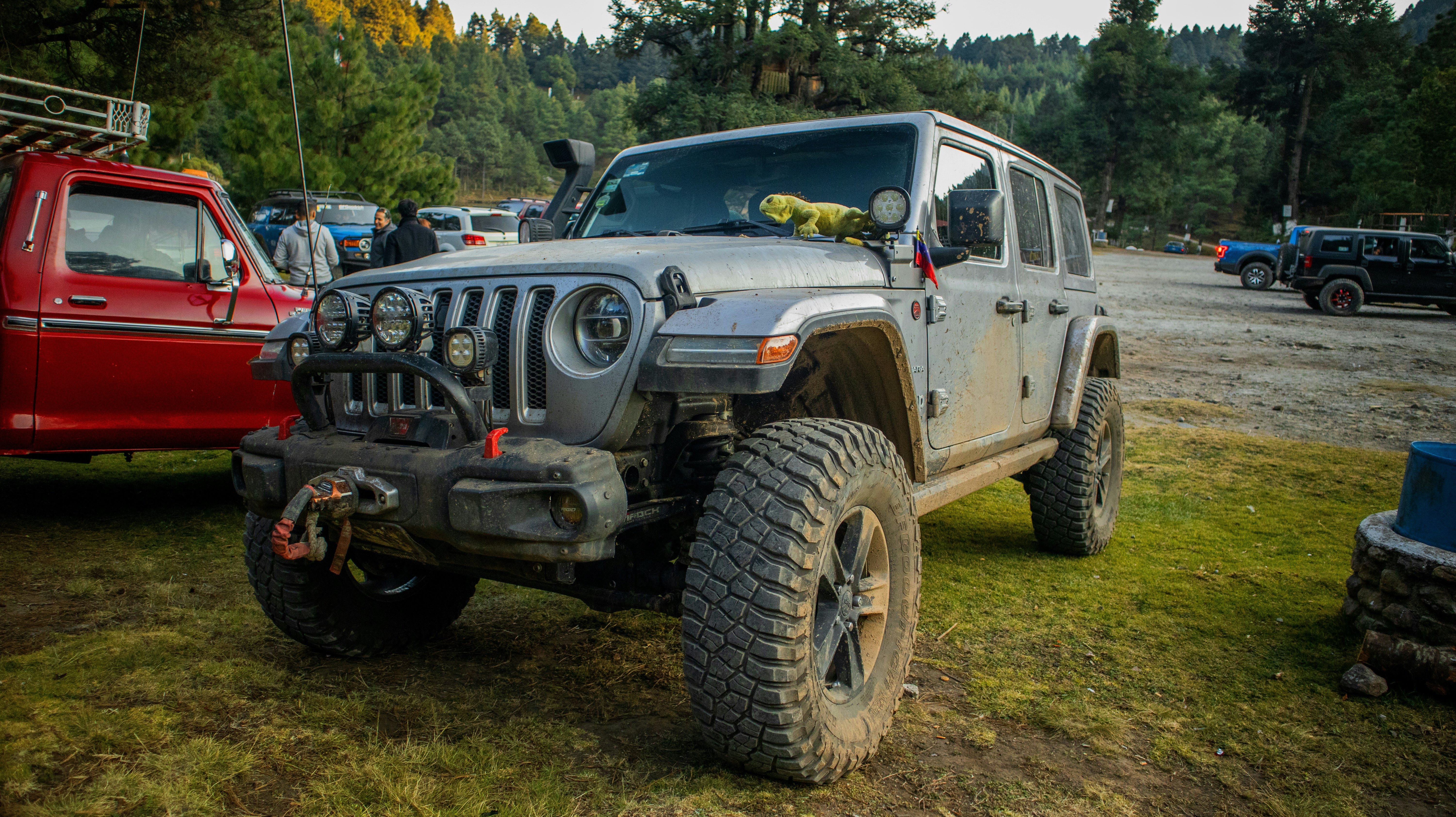a jeep is parked next to a red truck