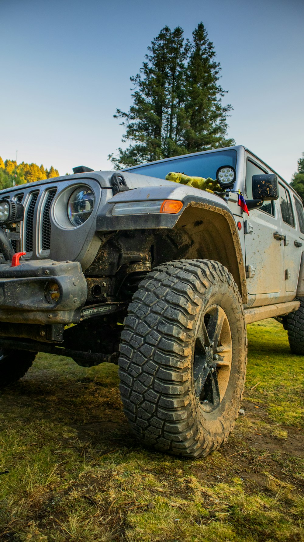 a jeep is parked in a field with trees in the background