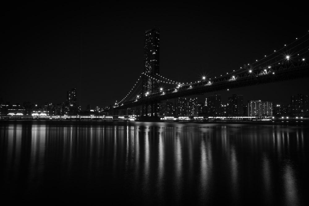 a black and white photo of a bridge at night