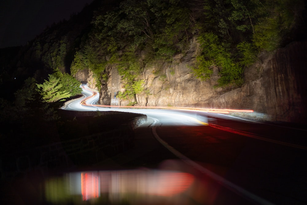 a long exposure photo of a road at night