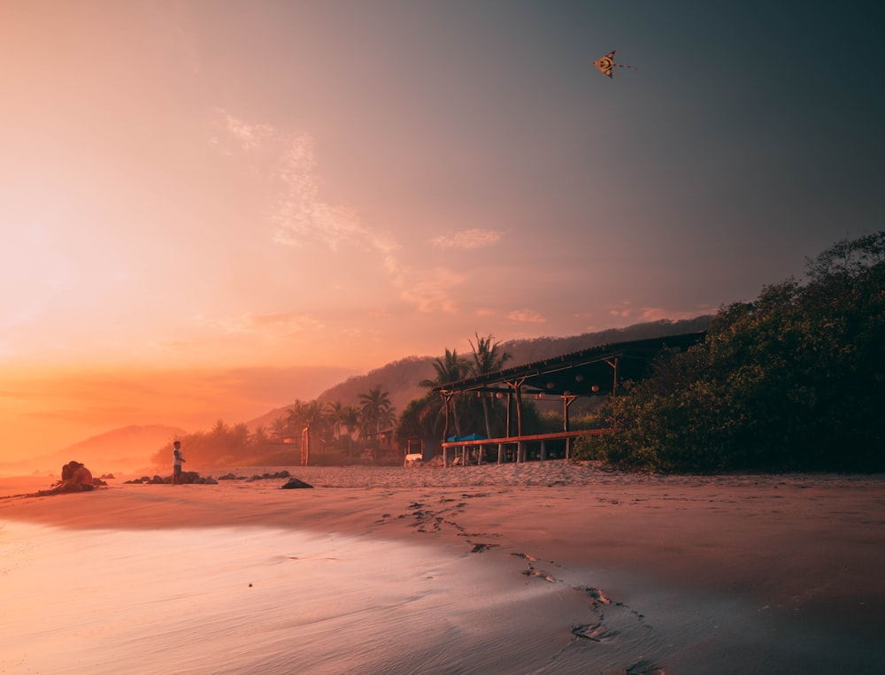 uma praia ao pôr do sol com pegadas na areia