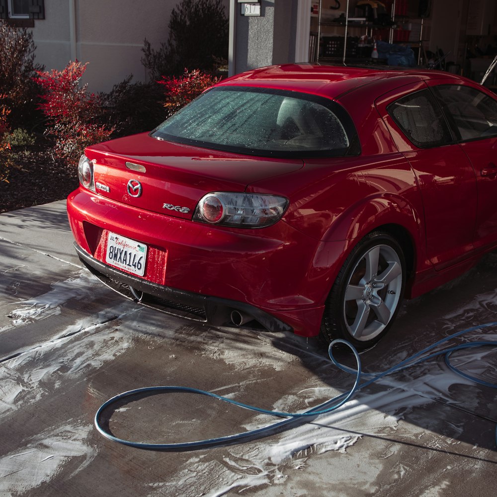 a red car is hooked up to a hose