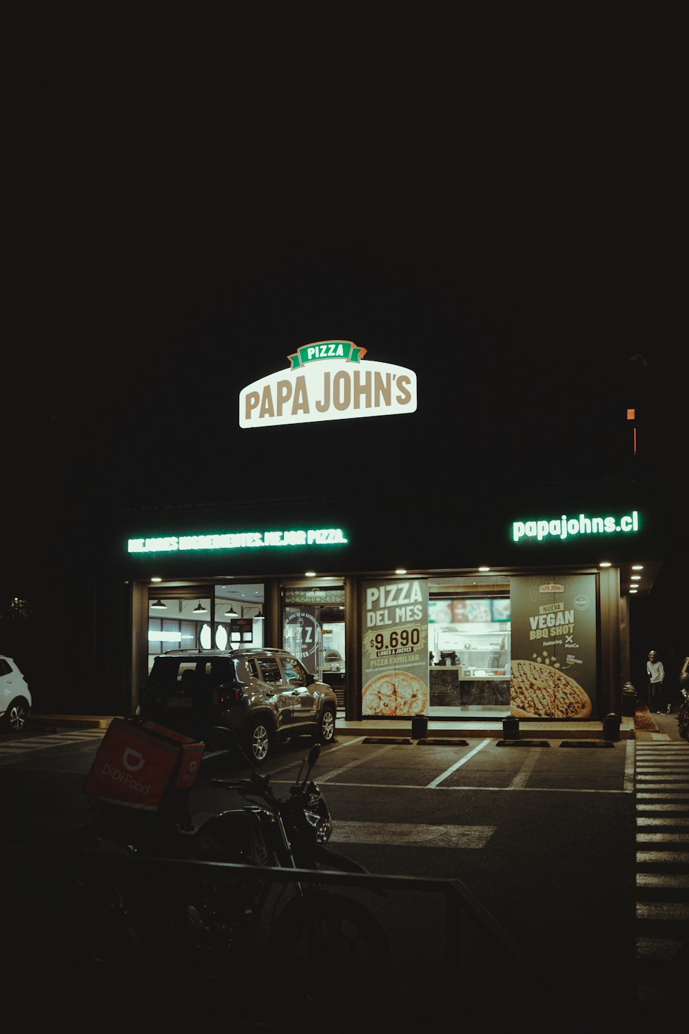 a pizza shop with a motorcycle parked in front of it