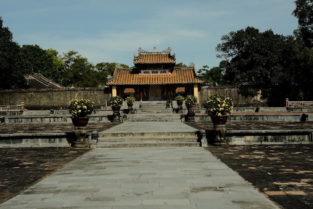 a stone walkway leading to a building with a pagoda in the background