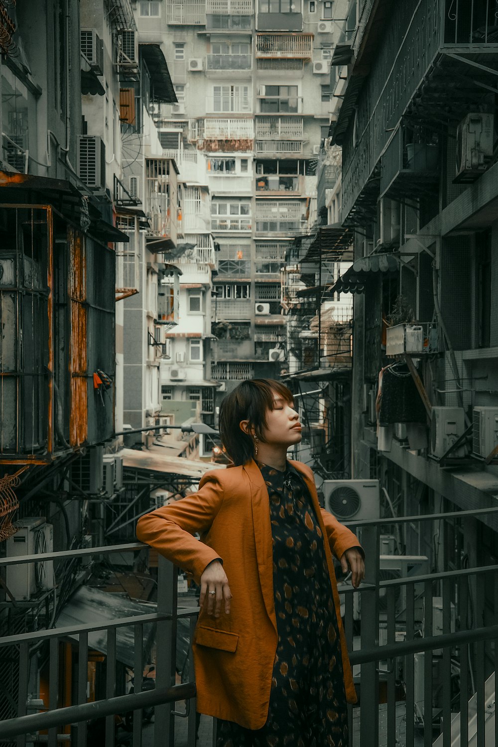 a woman standing on a balcony in a city