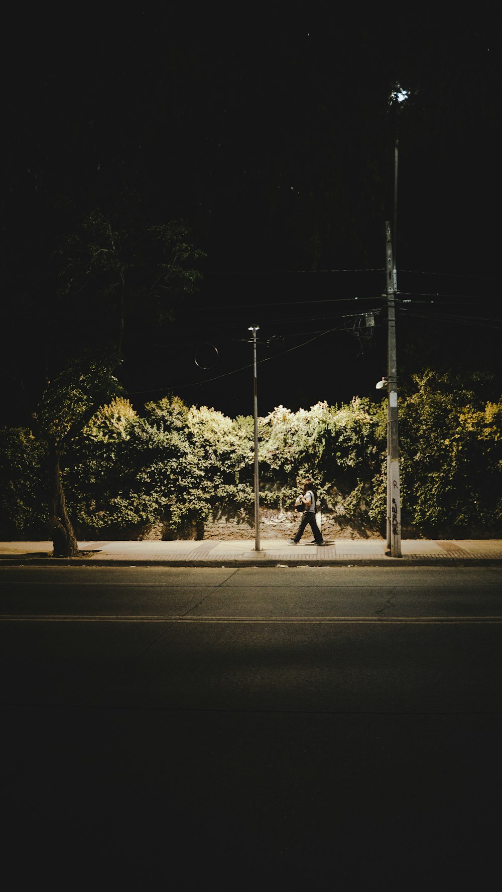 a person walking down a street at night