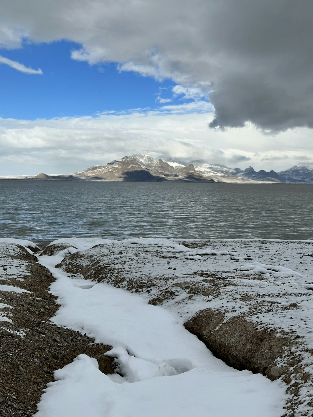 a snow covered beach with a mountain in the background