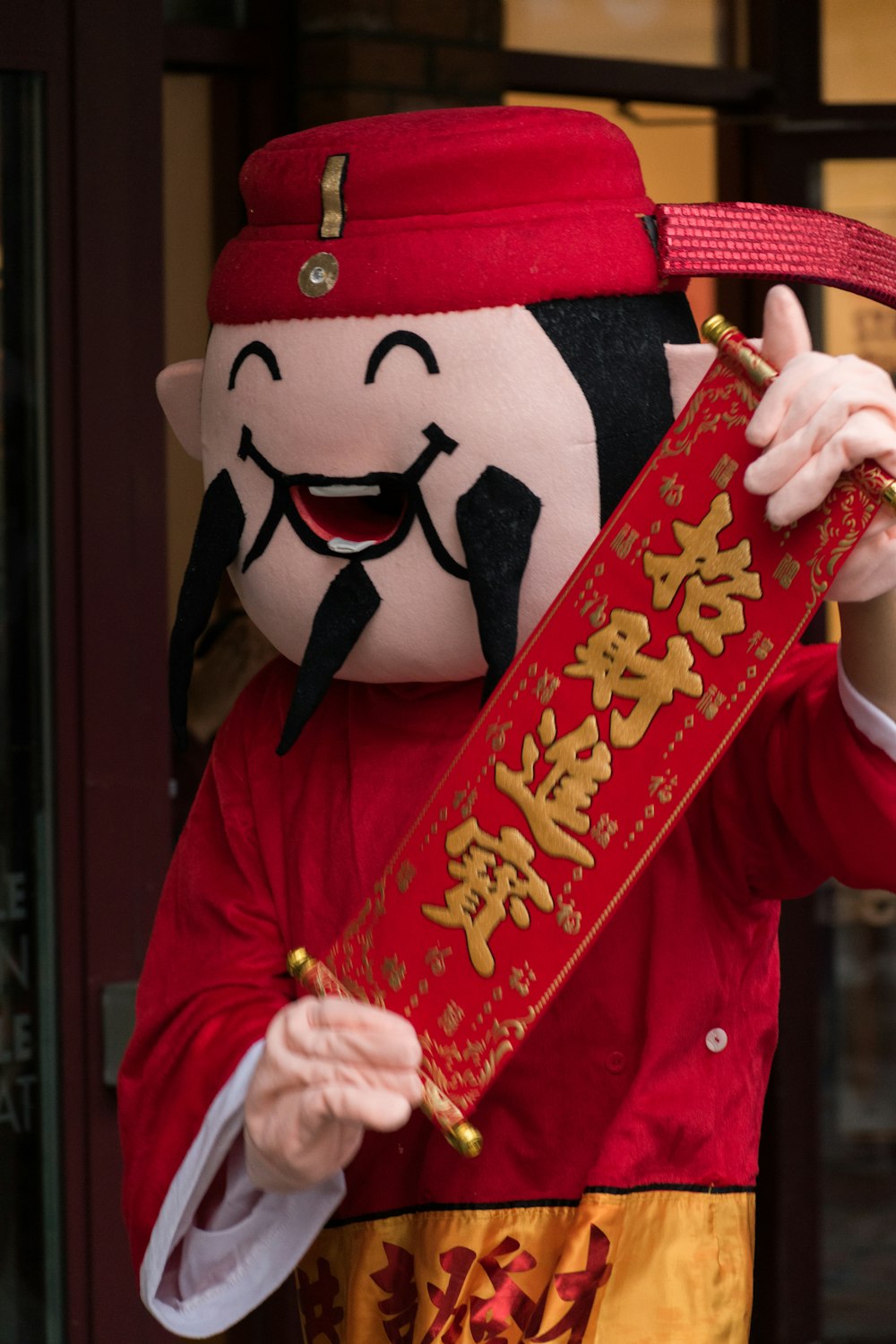 a person in a red and gold outfit holding a red box