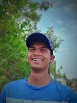 A person smiling while listening to music on their phone with Spotify open.