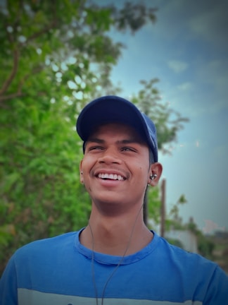 Smiling person listening to a guided session outdoors, surrounded by trees.