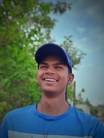 A person wearing headphones, smiling while listening to a Christian audiobook outdoors.