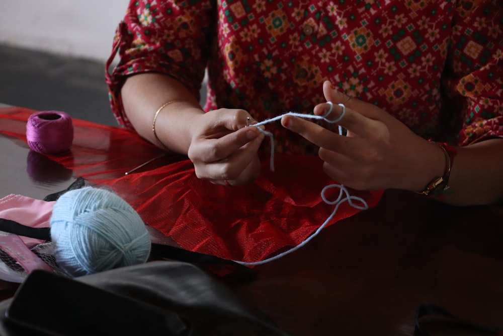 a woman is knitting a piece of cloth